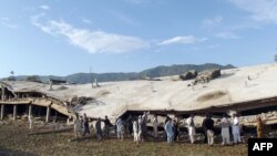 Residents gather beside a collapsed building following an earthquake in the Koga area in Buner district, Pakistan in October (file photo).