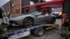 A police officer looks on as a luxury vehicle in the case against media influencer Andrew Tate is towed away on the outskirts of Bucharest on January 14.
