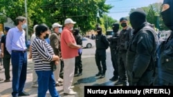 Прибывшие на объявленный двумя оппозиционными группами митинг граждане напротив сотрудников спецподразделения полиции. Алматы, 6 июня 2020 года.