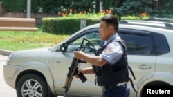 A police officer responds in Almaty after a gunman targeted police and left seven people dead.