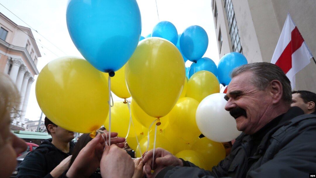 Belarusian opposition protesters share blue and yellow balloons to show their solidarity with Ukraine, during a rally marking the unofficial Freedom Day in Minsk on March 25. 