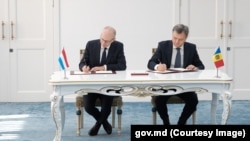 Premierul moldovean Dorin Recean (stânga) și prim-ministrul Luxemburgului, Luc Frieden