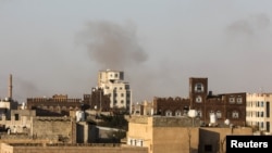 Smoke rises over the Yemeni capital, Sanaa, after the city's airport was hit by Israeli air strikes on December 26