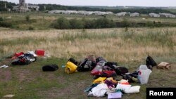 Випотрошений багаж жертв складений збоку на місці катастрофи, фото 18 липня 2014 року
