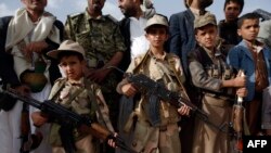 Yemeni children carrying weapons take part in a gathering organized by Shiite Huthi rebels to mobilize more fighters to battlefronts to fight pro-government forces, in the capital Sanaa, June 18, 2017