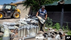 A farmer collects fragments of Russian rockets that landed in his field 10 kilometers from the front line in the Dnipropetrovsk region of Ukraine on July 4.
