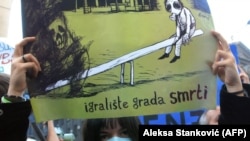 Stanovnica Pančeva tokom protesta zbog zagađenja drži poster sa crtežom dečjeg igrališta (novembar 2006)