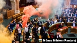 A Momentum képviselői füstgyertyákkal tiltakoznak a gyülekezési jogról szóló törvény módosítása ellen az Országgyűlés plenáris ülésén 2025. március 18-án