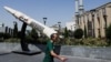 A man walks next to a symbolic mock-up of an Iranian missile, on a street in Tehran in June.