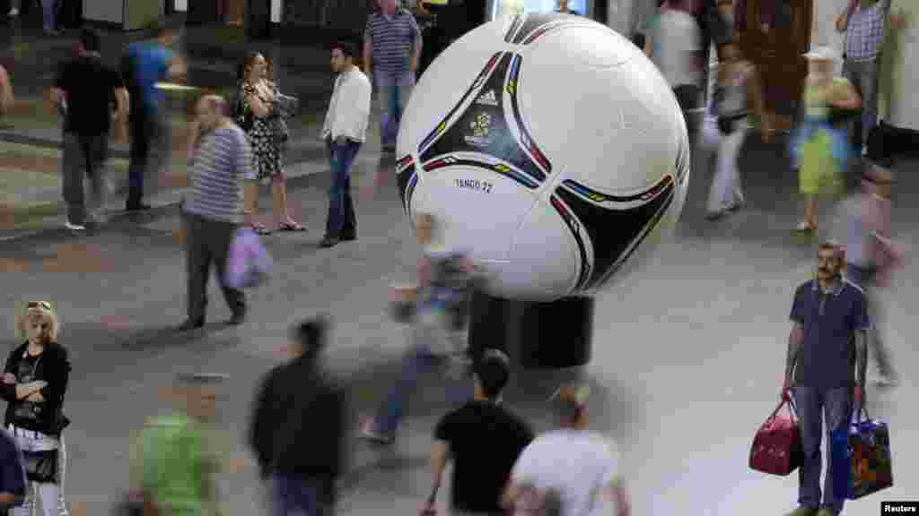 People walk past a giant model of Tango 12, the official ball of the Euro 2012 soccer tournament, at the Central Railway Station in Kyiv, Ukraine, on May 29. (Reuters/Gleb Garanich)