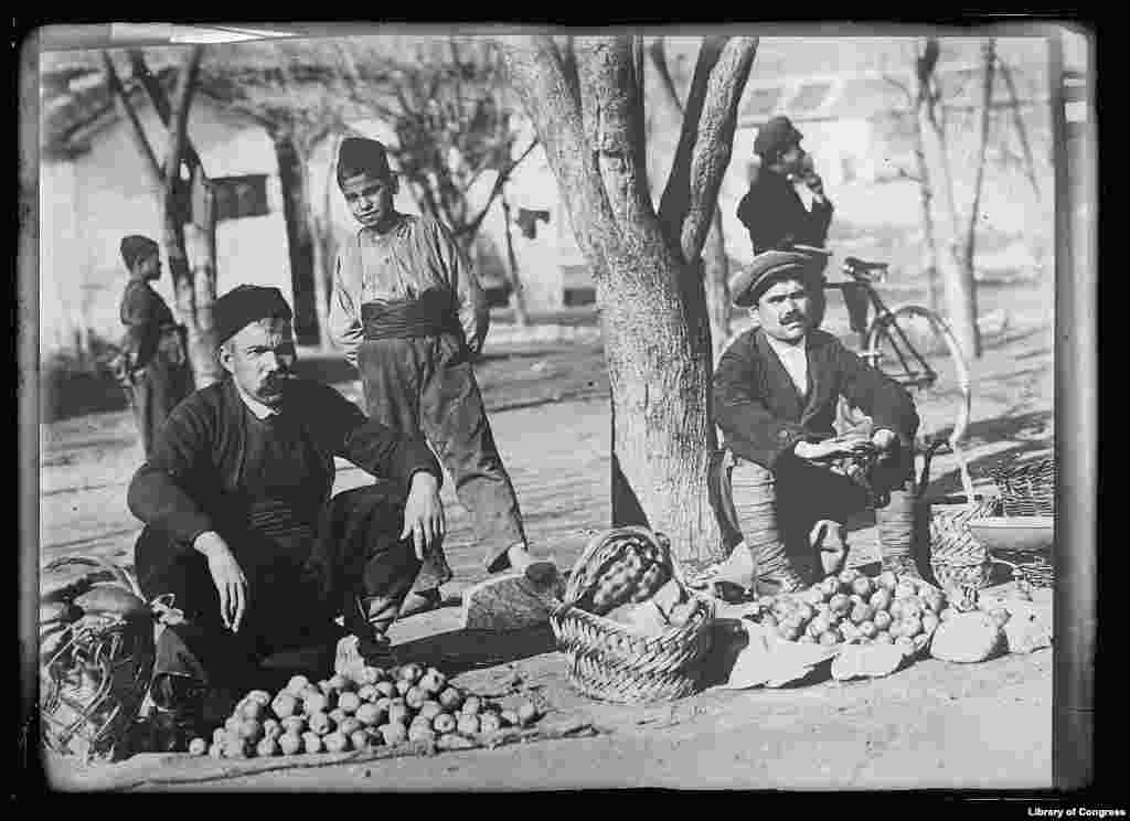 Продавцы, у каждого из которых был запас еды на целый день, ждут покупателей на&nbsp; уличном рынке в Кавалле, что на севере Греции, в ноябре 1919 года. В большинстве районов Балкан было так мало еды, что они продавали картошку и другие овощи по частям