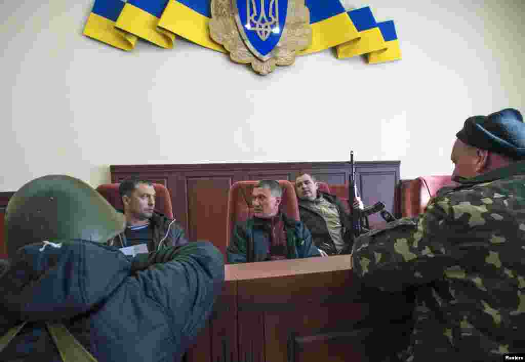 Проросійські протестувальники з бойовою зброєю всередині захопленого офіса СБУ у Луганську, 7 квітня 2014 року