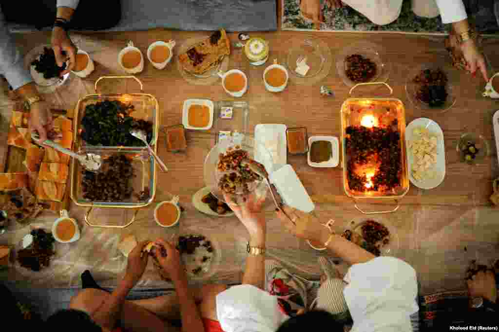 Семья мусульман в США, выходцев из Йемена, за завтраком в первый день Ид аль-Фитра. На столе - традиционные йеменские блюда. Бруклин, Нью-Йорк.