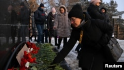 Люди приносят цветы к памятнику "Памяти шахтеров Кузбасса" после аварии на угольной шахте "Листвяжная" в Кемерово