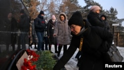 People lay flowers at an impromptu shrine to pay tribute to the miners and rescuers killed in an accident at the Listvyazhnaya coal mine in Kemerovo. 