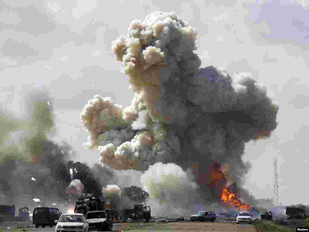 Возила на либијската војска горат во близина на Бенгази - Vehicles belonging to forces loyal to Libyan leader Muammar Gaddafi explode after an air strike by coalition forces, along a road between Benghazi and Ajdabiyah March 20, 2011. REUTERS/Goran Tomasevic (LIBYA - Tags: POLITICS CIVIL UNREST CONFLICT)