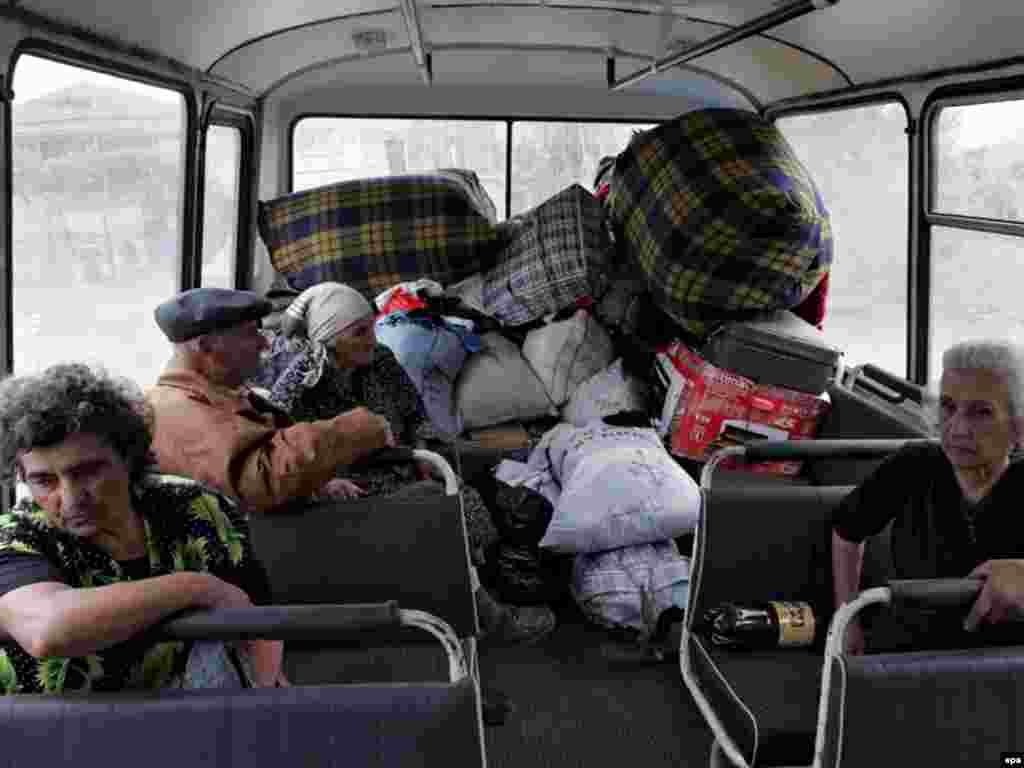 Беженцы из грузинского села Курта (близ Цхинвали) уезжают из своих домов, опасаясь мести осетинов, на автобусах, предоставленных Министерством по чрезвычайным ситуациям РФ, 20 августа 2008
