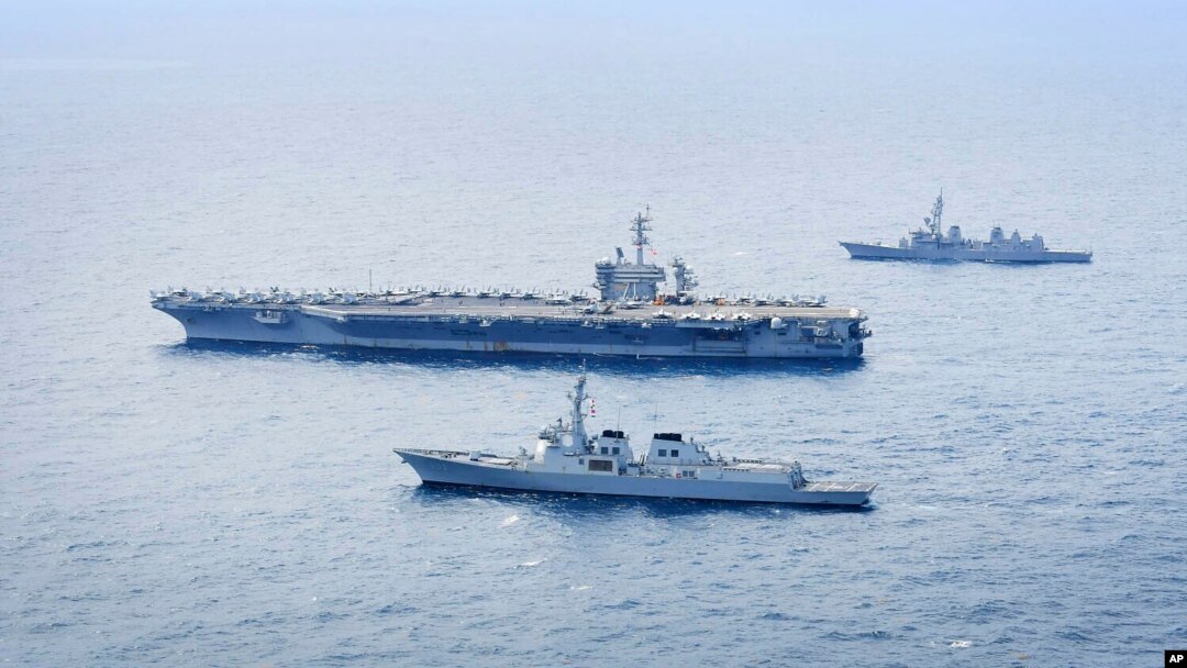Distrugătorul Seoae Ryu Sung-ryong al marinei sud-coreene, în partea de jos, portavionul Theodore Roosevelt al Marinei SUA, în centru, și distrugătorul Ariake al Forței Maritime de Autoapărare a Japoniei, sus, în timpul unui exercițiu naval comun din 11 aprilie 2024.