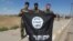 Iraqi Sunni and Shi'ite fighters pose for a photo with a captured Islamic State flag in Al-Alam, northeast of Tikrit, on March 17.
