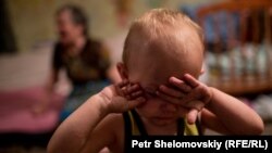 Ребенок плачет в бомбоубежище в Петровском районе Донецка, июнь 2015 года
