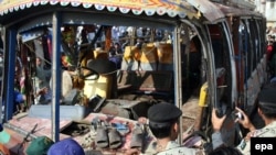 Pakistani paramilitary soldiers inspect the damaged bus at the scene of a deadly bomb blast in Karachi today.