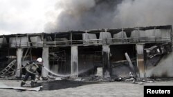 
Пожежник на місцевому ринку, який нещодавно був пошкоджений в результаті обстрілу в Донецьку, 3 червня 2015 року
