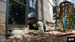 An Israeli firefighter takes cover in Kiryat Shmona, an evacuated city in northern Israel that frequently comes under rocket attacks launched by Hezbollah militants across the border in Lebanon.