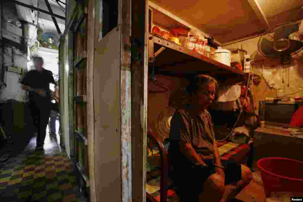 A woman sits inside her 2.2-square-meter &quot;cubicle&quot; home in this 2009 photo.