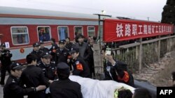Китайские полицейские несут раненного шахтера. Провинция Шаньси.