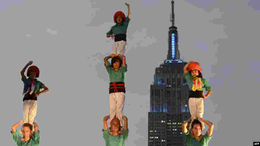 Part of the 150-member Castellers de Vilafranca form a tower configuration after they build an eight-level human tower on a rooftop in New York. (AFP/ Timothy A. Clary)