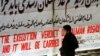 Мальчик читает на стене Тегеранского университета плакат, на котором написано: "Казнь Рушди будет приведена в исполнение" 
