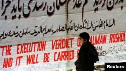 A banner saying "the execution verdict of Salman Rushdi will be carried out" is hung at Tehran University in 2012. A year after Rushdie's The Satanic Verses was published in 1988, Iranian leader Ayatollah Ruhollah Khomeini issued a fatwa calling for Rushdie's death.