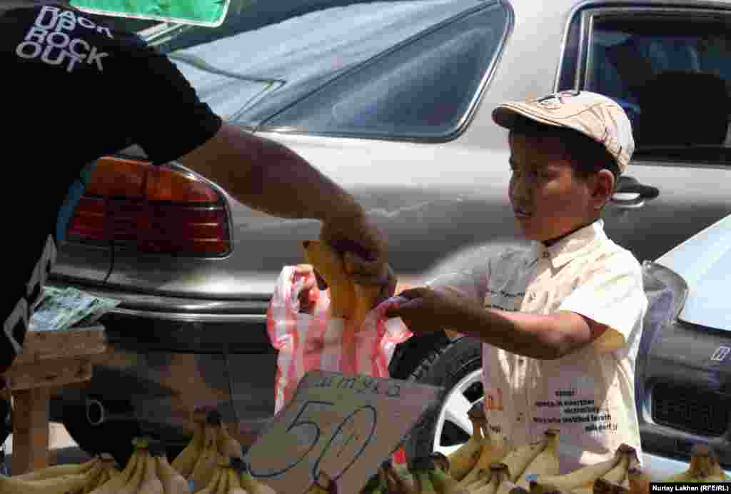 Казахстан. Мальчик торгует бананами на улицах Алматы