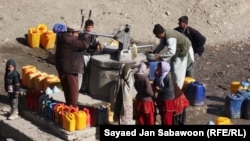 Afghanistan - Afghan's fill cans with drinking water from a community tap in Kabul on January 17, 2011