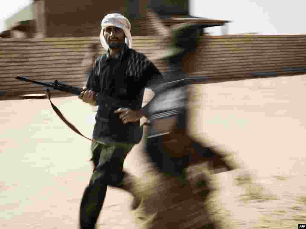 Libyan rebel fighters search for soldiers loyal to Muammar Qaddafi in Um al-Far after taking control of the village on July 28. Photo by Alessio Romenzi for AFP