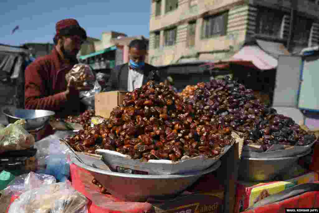 An Afghan street vendor sells dates ahead of Ramadan at a roadside stall in a Kabul market on April 23.