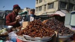 Уличный торговец в Афганистане продает финики перед Рамаданом рядом с рынком в Кабуле.