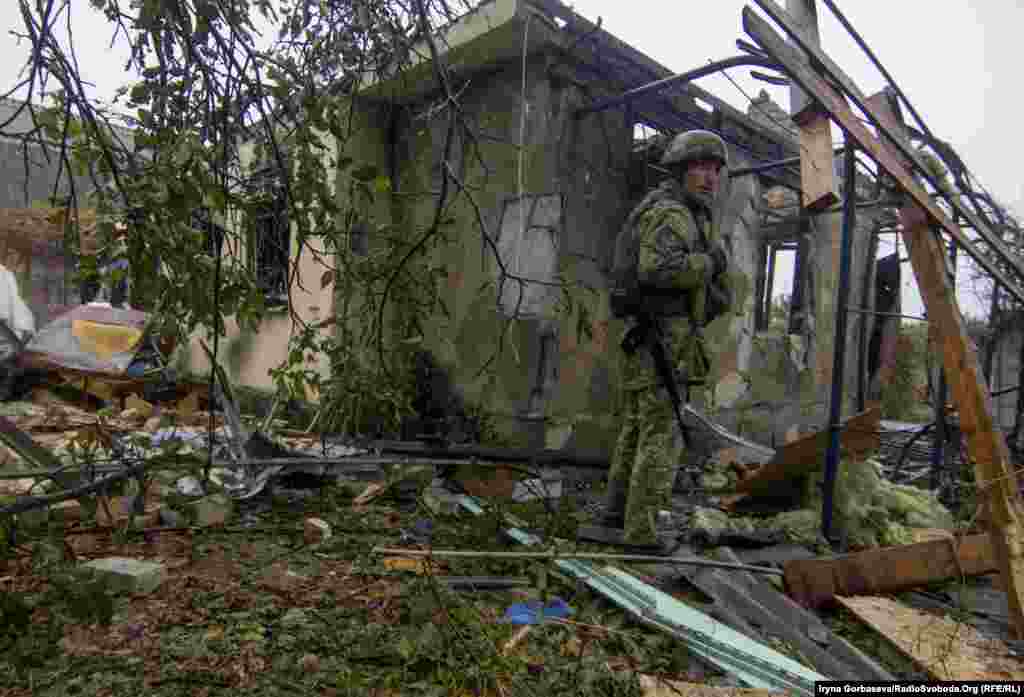 Український військовий оглядає будинок, розбитий внаслідок артилерійського обстрілу села Водяне неподалік Маріуполя, 13 жовтня 2016 року