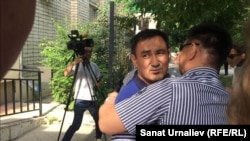 Валихан Разов, бывший начальник областного департамента по регулированию естественных монополий, обнимает родственника после приговора. Уральск, 14 июня 2016 года. 