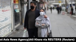 A couple walks in Enghelab Square in Tehran on March 26. Amid a deadly outbreak of coronavirus in Iran, alleged miracle cures and misinformation have spread online.