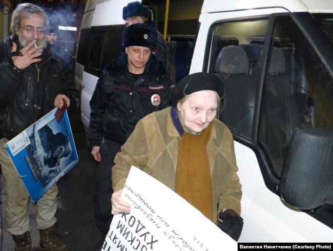 Елену Осипову ведут к полицейской машине