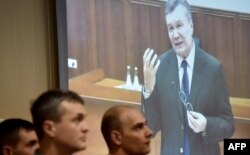 Former Ukrainian president Viktor Yanukovych is seen via live video link from Russia as a witness at the trial of five ex-riot police officers accused of shooting Ukrainian protesters in Kyiv in 2014