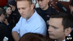 Russian opposition figure Aleksei Navalny (center) and RPR-Parnas opposition party candidate Ilya Yashin (right) speak with voters in the town of Kostroma on September 13.