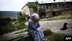 Жена од Грузија плаче на местото каде била уништена зградата во која живеела. 