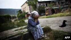 A Georgian woman cries at the entrance of her destroyed building in a battered neighborhood in Gori on August 23, 2008.