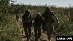 Donetskde ukrain harbylary ýaralanan esgeri ewakuasiýa etmäge kömek edýärler.