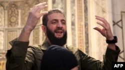 Abu Muhammad al-Jolani, leader of the U.S. designated terrorist group Hayat Tahrir al-Sham, addresses a crowd at Damascus's landmark Umayyad Mosque on December 8.