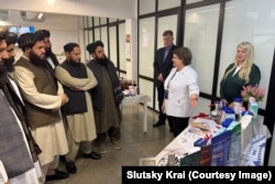 Members of a Taliban delegation listen to a woman describe baby formula products at a factory in Belarus.