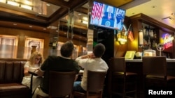 Clienții urmăresc pe ecran, la Brooklyn Diner din Times Square, New York, SUA, discursul președintelui american Donald Trump, pe 1 aprilie 2026.