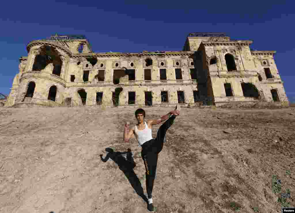 Abbas Alizada, who calls himself the Afghan Bruce Lee, poses in front of the destroyed Darul Aman Palace in Kabul. (Reuters/Mohammad Ismail)